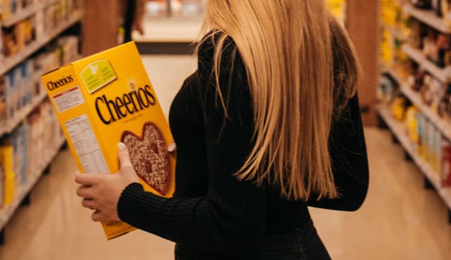 lady holding cheerios wondering if a dog can consume it